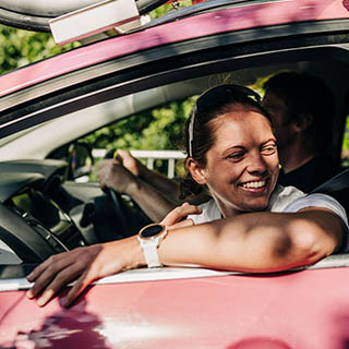 Meg is smiling in a car at a cycle race.