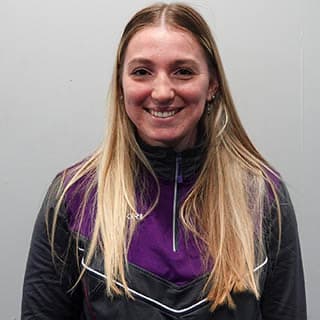 Zoe, a physio administrator, has blond hair and is smiling.