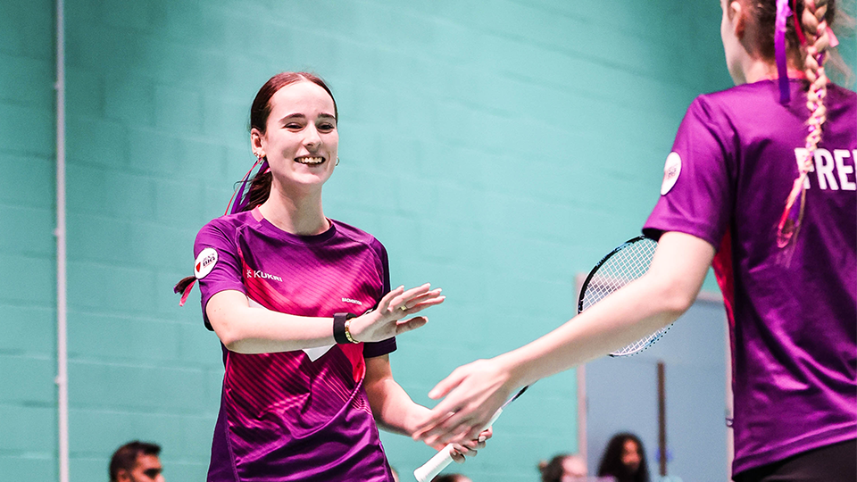 two badminton players high fiving