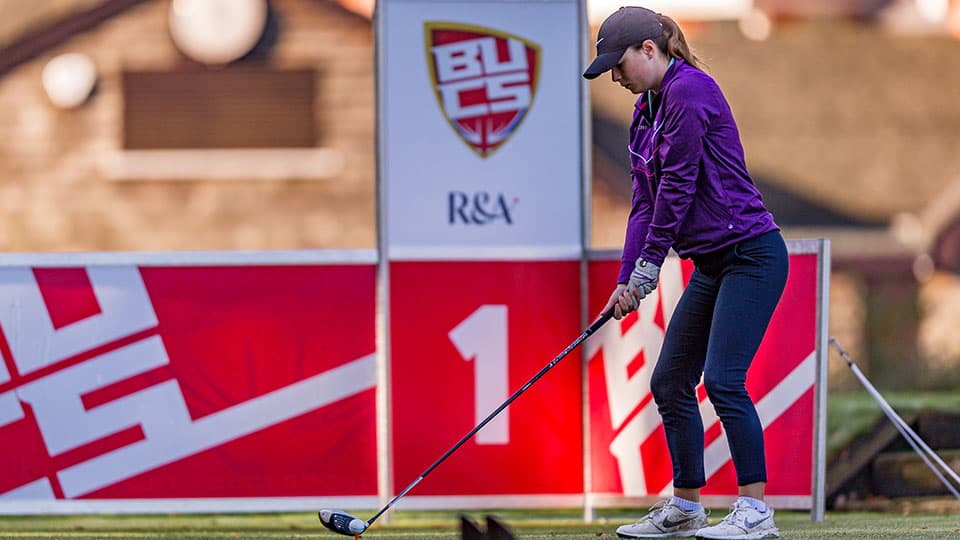 a player about to hit the ball, a BUCS banner is in the background