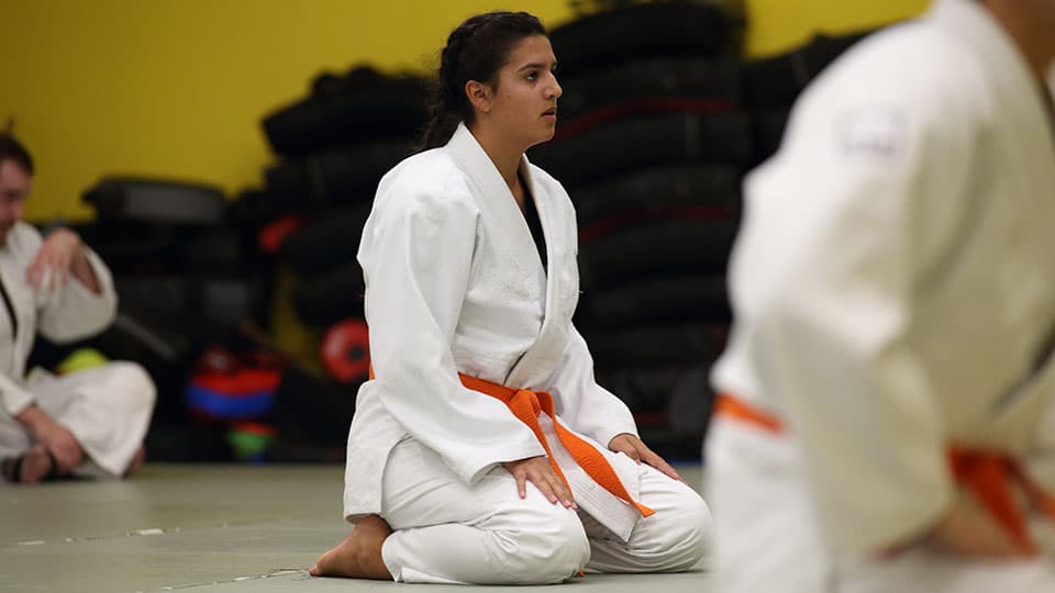 A Jiu Jitsu practitioner kneeling during a practice session