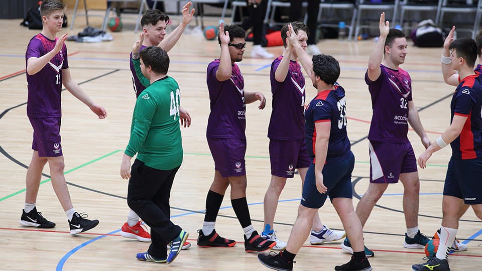 Korfball team players line up to high-five