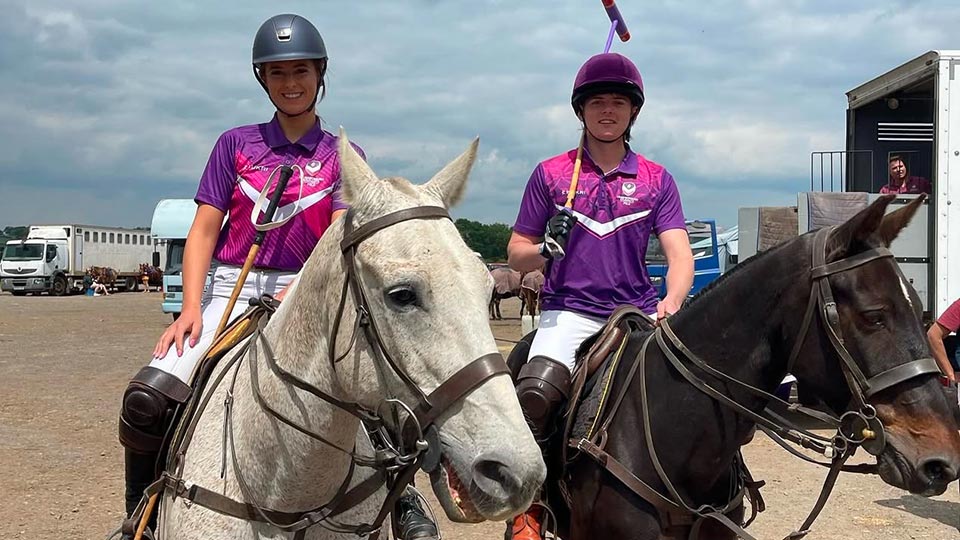 Two polo players wearing Loughborough kit on horses