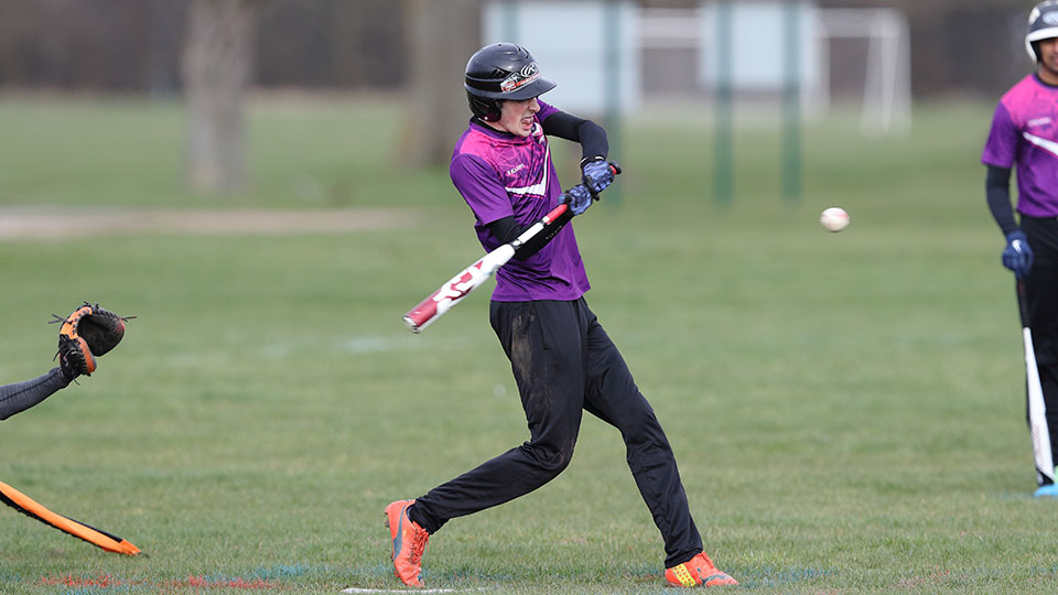 A baseball player wearing Loughborough kit preparing to hit the ball during a match
