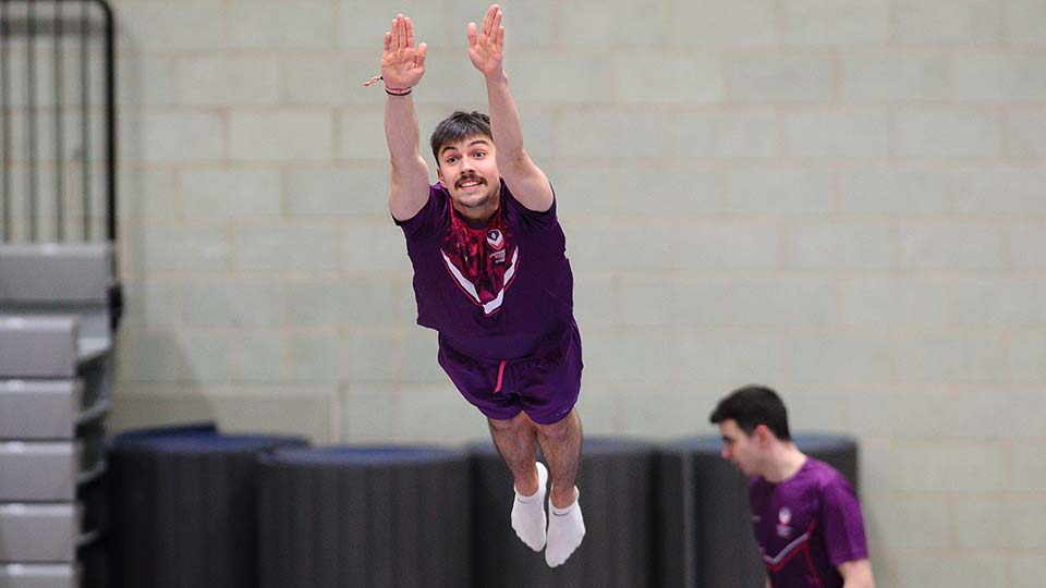 A male student mid air on a trampoline
