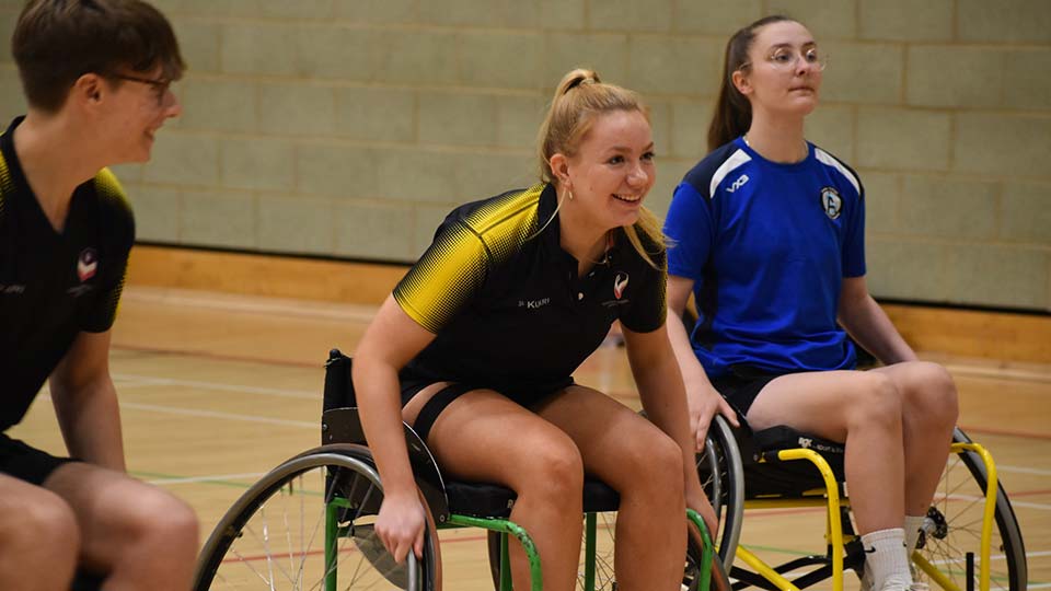Three wheelchair basketball players on the court
