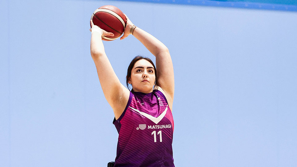 Wheelchair basketball player holding the ball above their head ready to take a shot