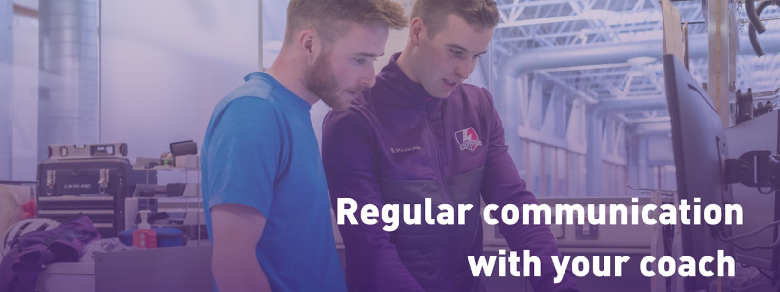 Max Holgate is speaking to a rider by a computer.