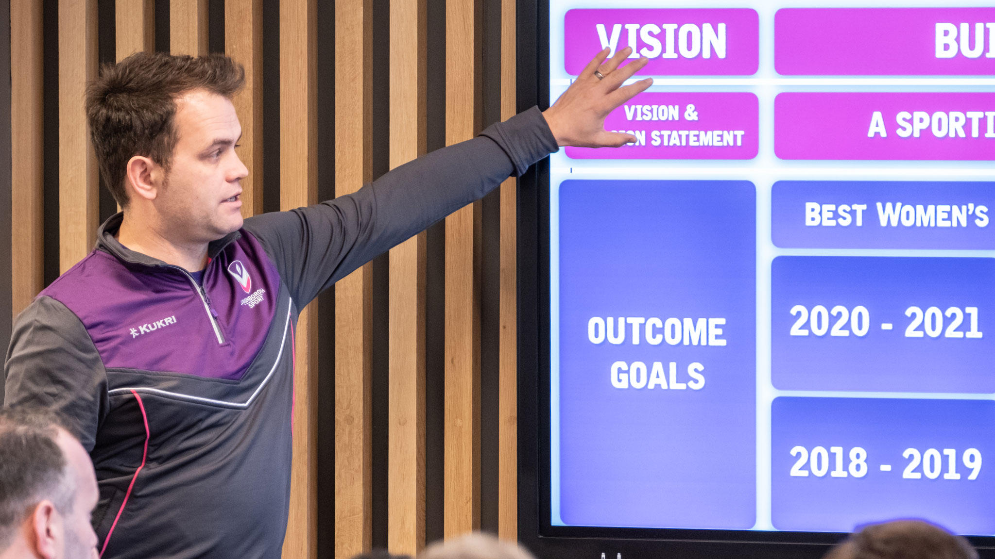 a man pointing to a presentation slide