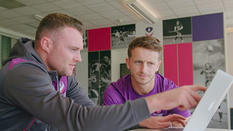 two men looking at a laptop screen