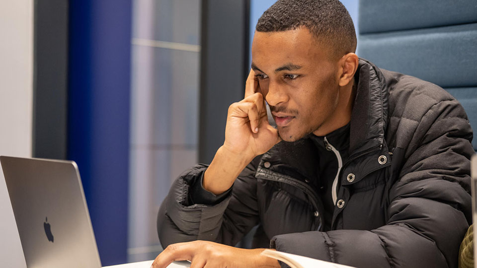 One student in a black top, studying quietly on his own.