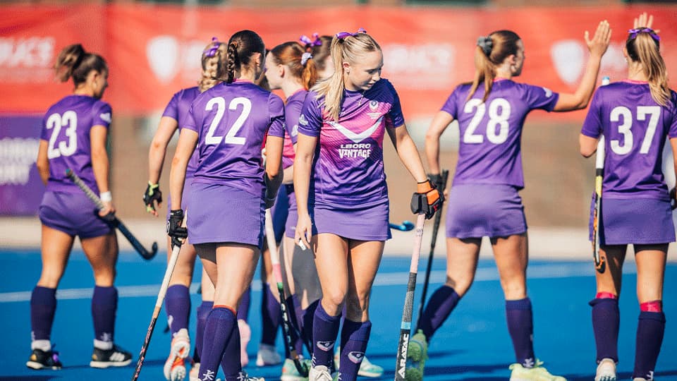a group of female students playing floor hokey