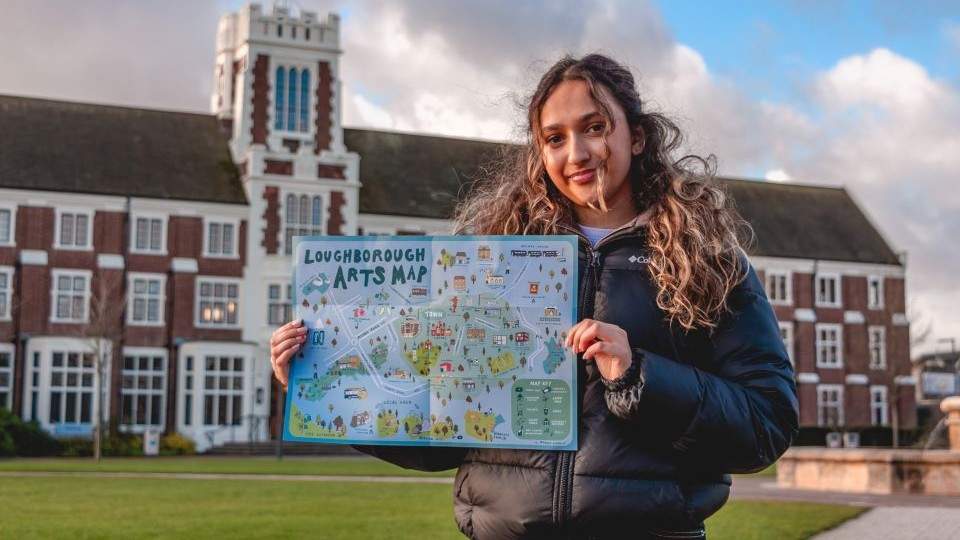 a student holding the arts map in from of the Loughborough campus