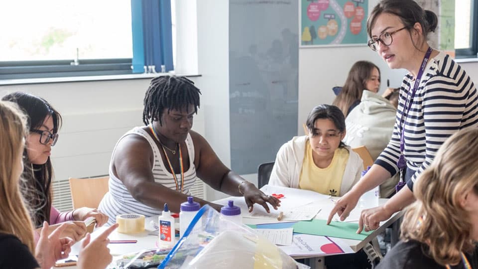 a group of people sitting around a table working on an activity