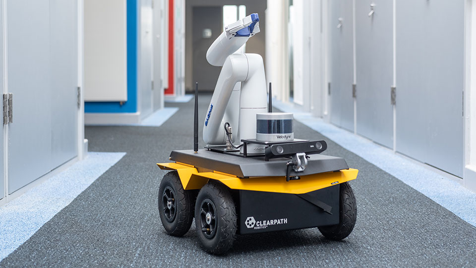 The Clearpath Jackal - wheeled extendable arm robot in a corridor