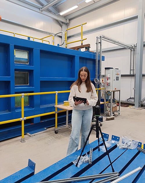 A student using a laser scanner inside the National Engineering Slope Simulator facility.