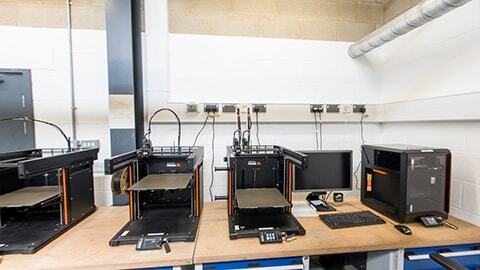 Four 3D printers setup on a desk