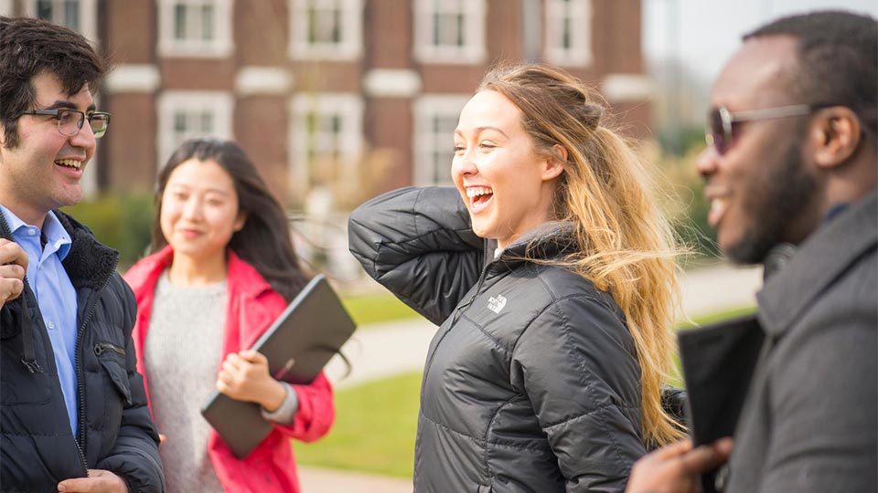 Smiling students outside Hazlerigg building