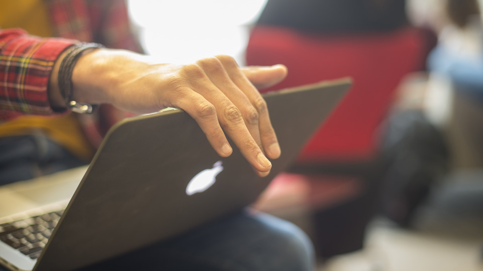 a person using a laptop computer on their knees