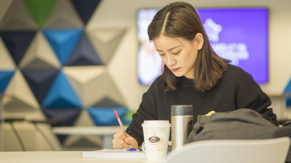 a student sitting at a table writing