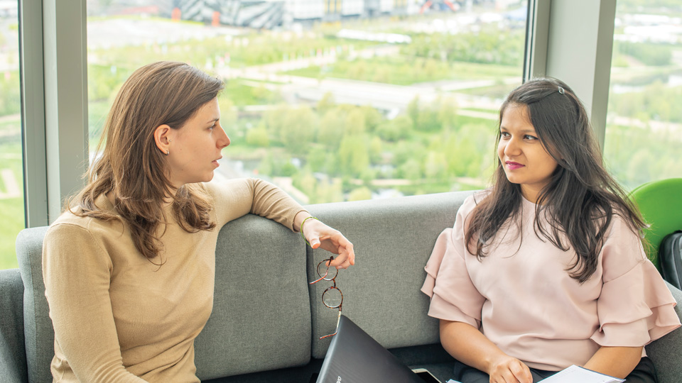 two students sitting on a sofa talking