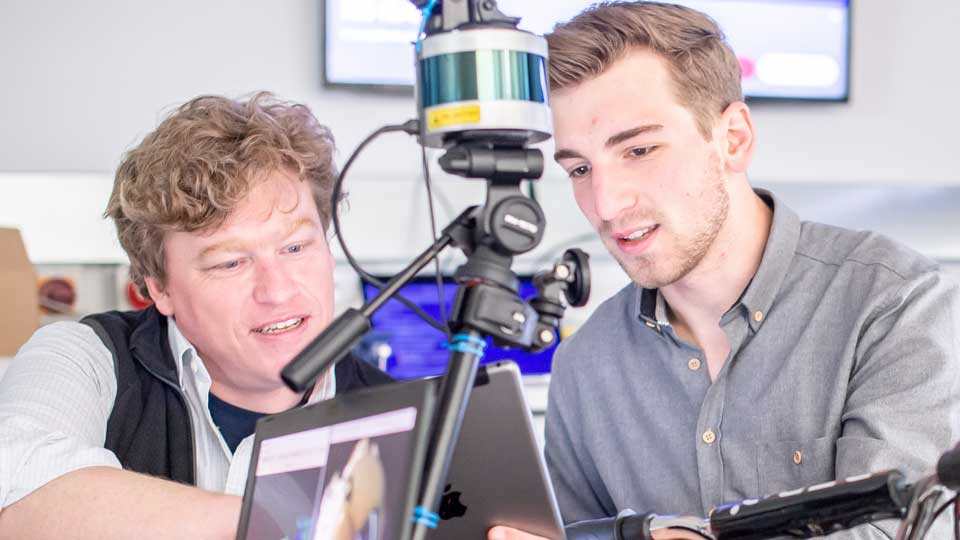two students using equipment in a workshop