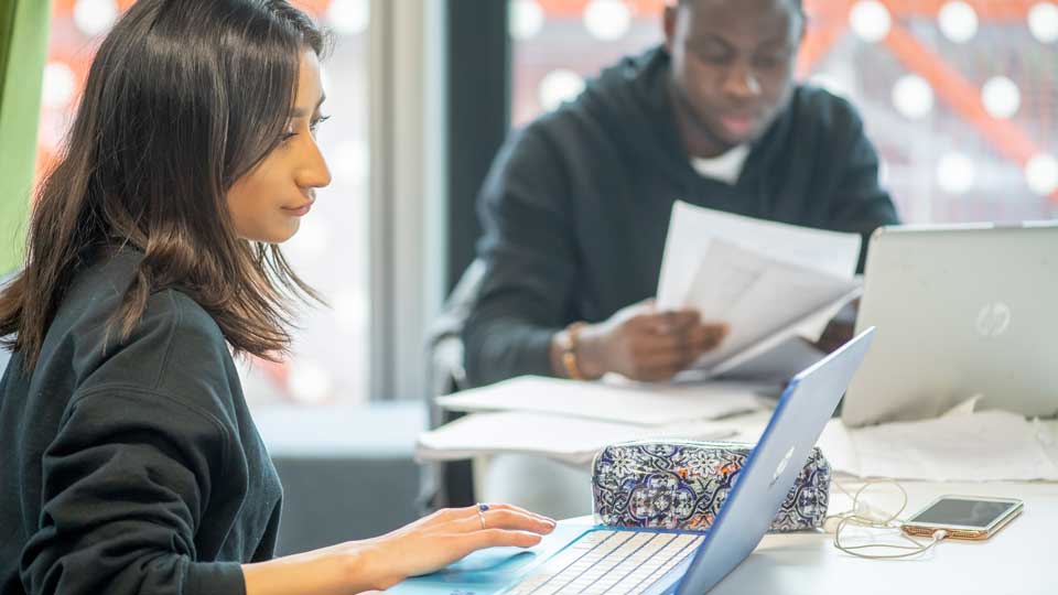 two students using laptop computers