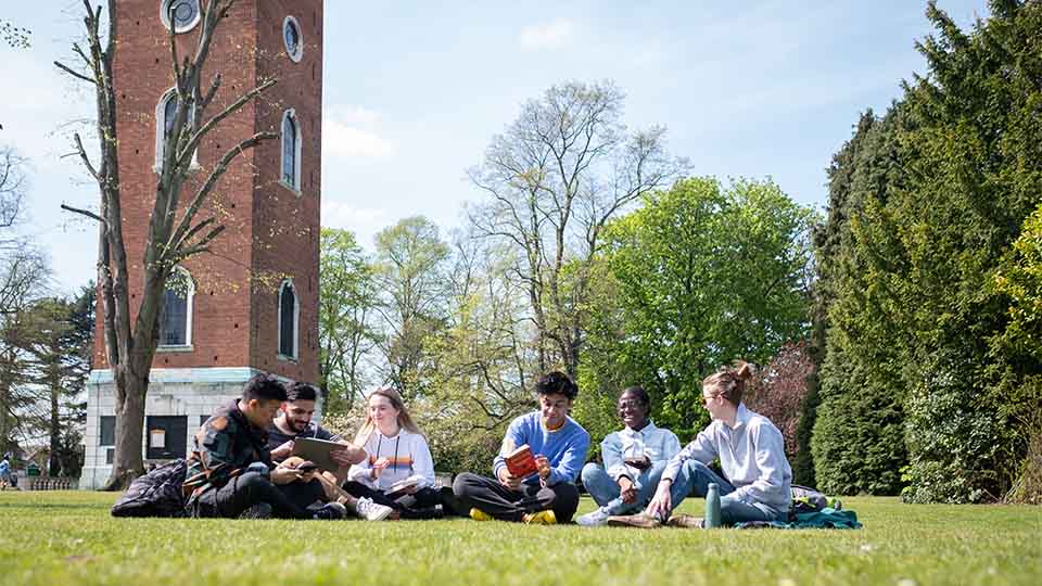 postgraduate students hanging out in Queen's Park on a sunny day