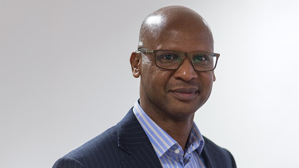 Ahmad stood against a grey background