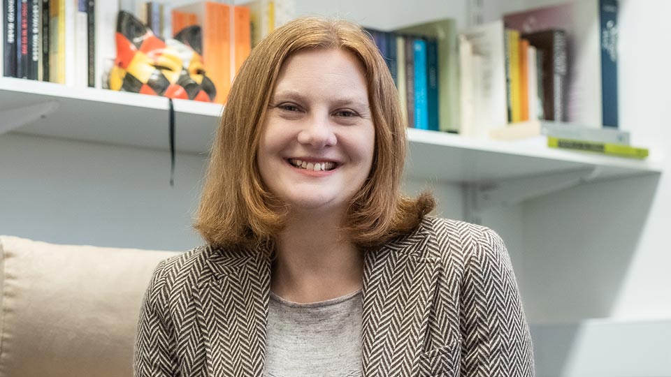 Catherine sat beside a bookshelf in the office