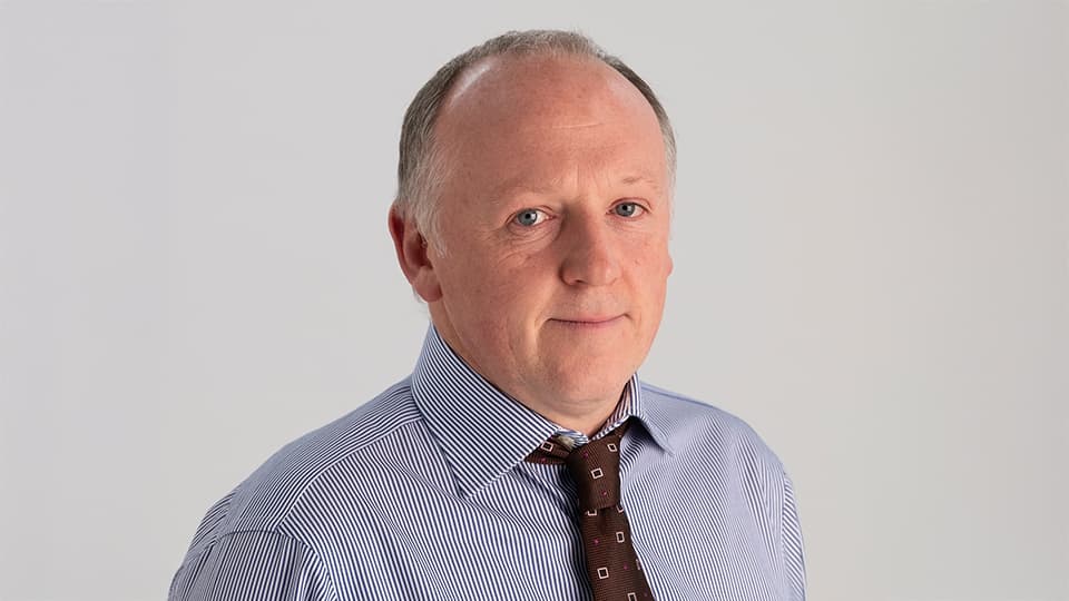 Darren stood against a grey background