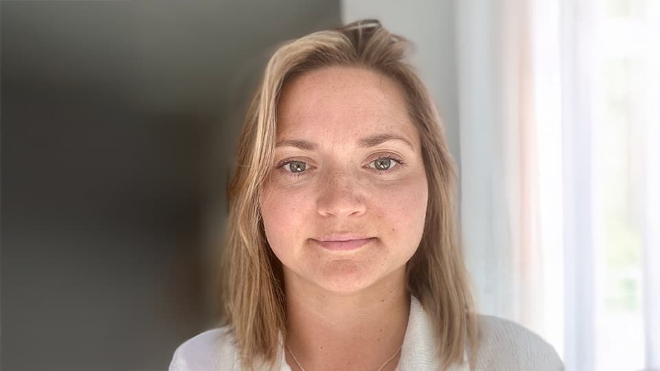 Kirsty stood against a white and grey background