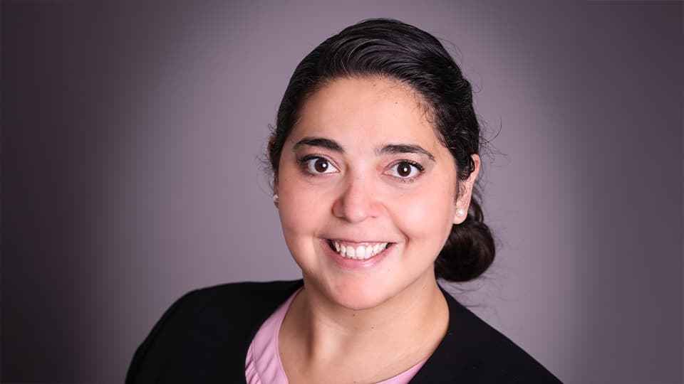 Laura stood against a dark grey background