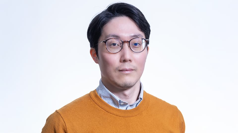 Masahiro stood against a white background