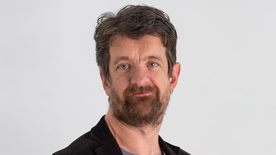 Michael stood in front of a grey background