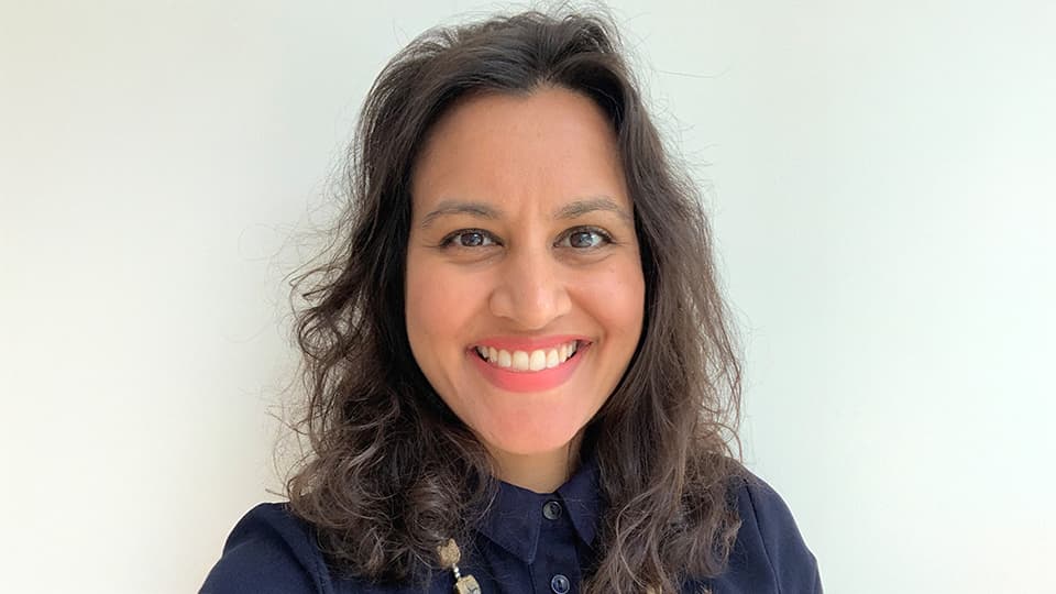 Neema stood against a grey background