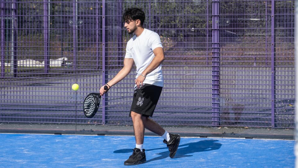 A male student playing padel