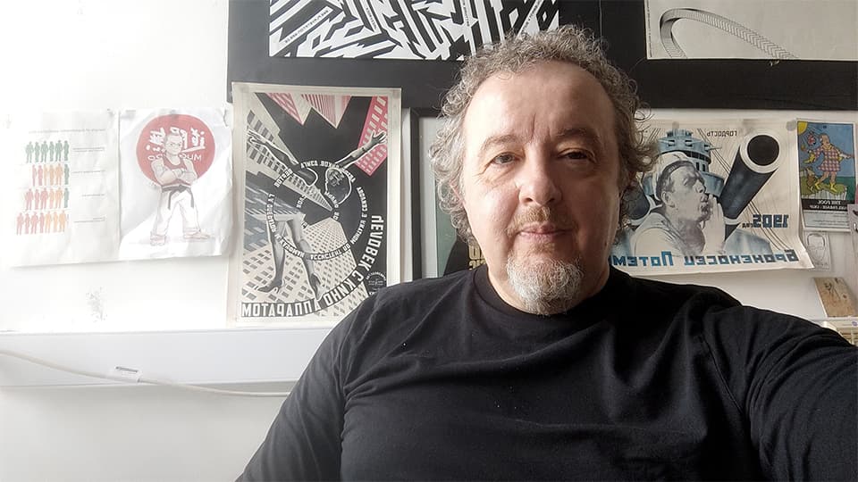 Simon sat in front of graphic design artwork