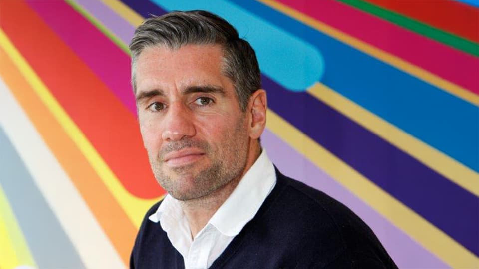 Stephen stood in front of a colourful background