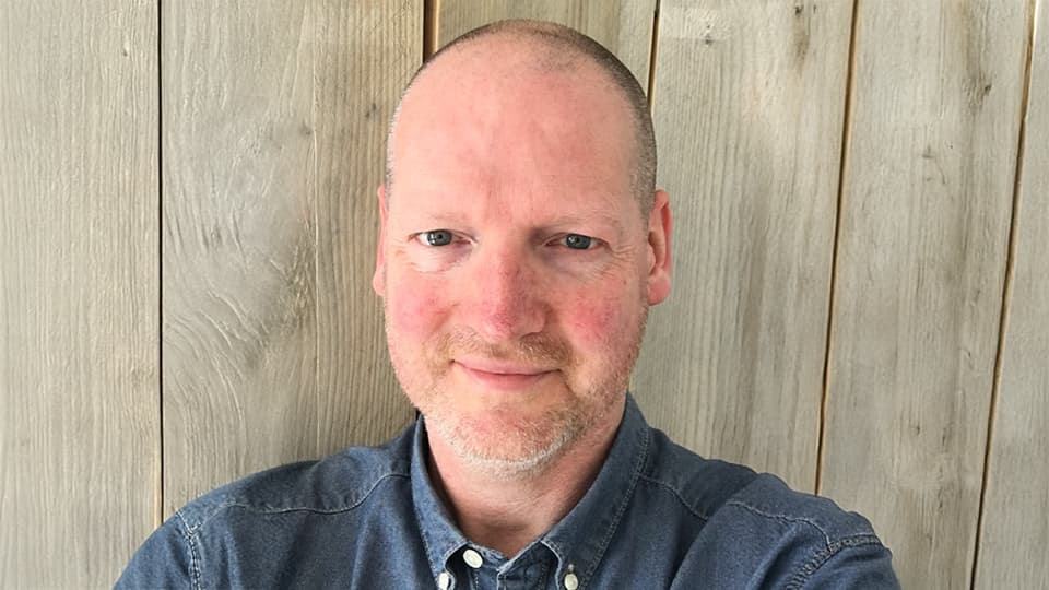 Steve stood in front of wood background