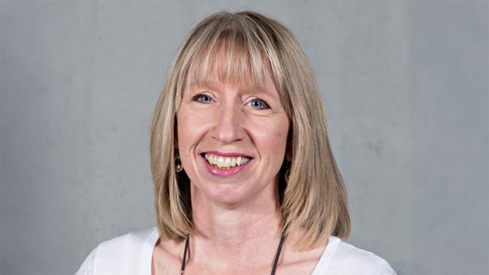 Tracy stood against a grey background