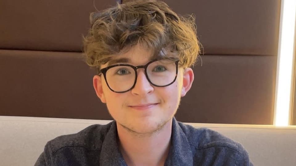 A male postgraduate student wearing glasses