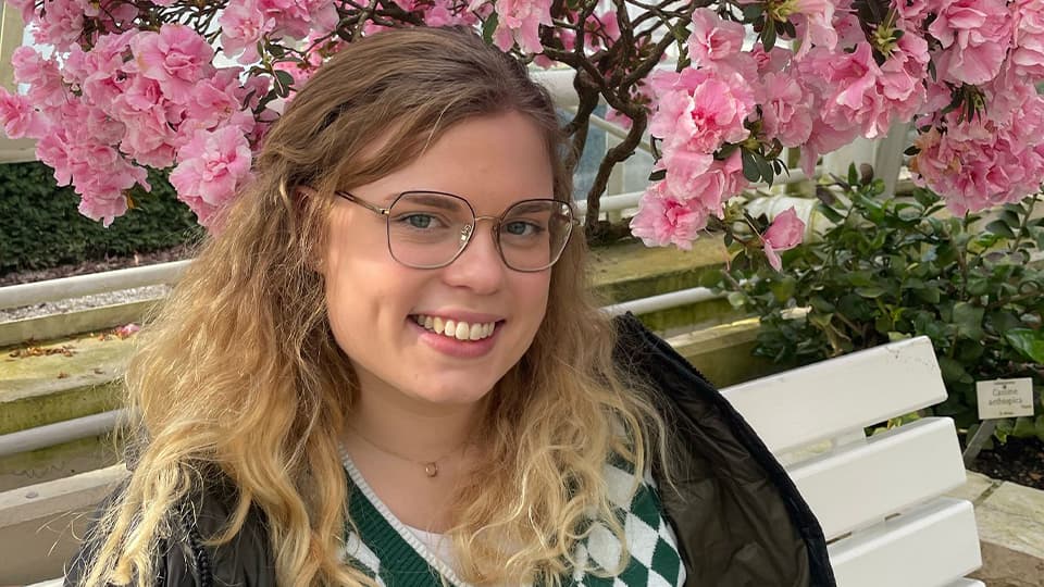 Lisa sat on a bench in a garden