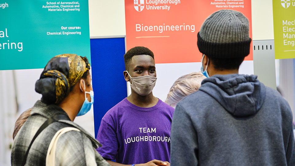 LUDUS. Student ambassador talking to parent and child.