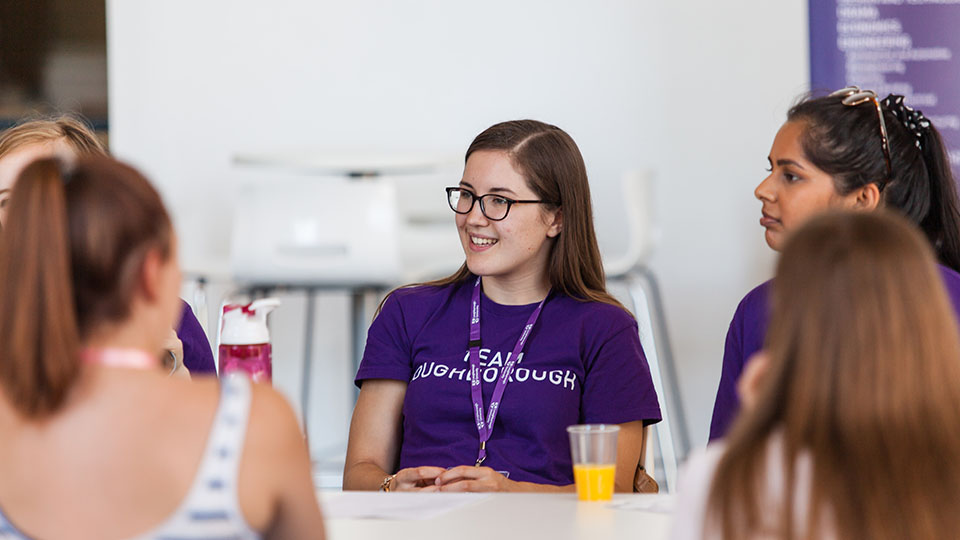 Student ambassador talking to prospective students around a table.