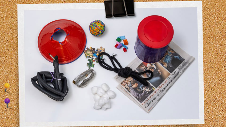 A picture of random equipment including newspaper, rope, cones, rubber bands.