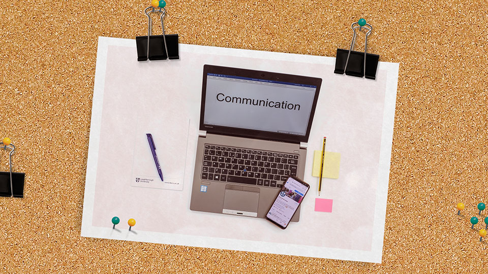 photo of laptop and mobile phone clipped to a notice board