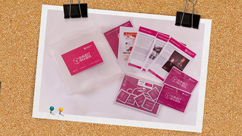 Photo of a plastic box with Subject in a Box written on it, surrounded with various worksheets and card activities.
