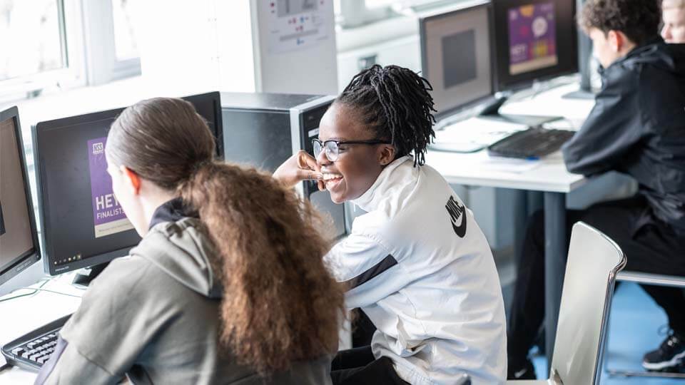 students sat talking at computer screens