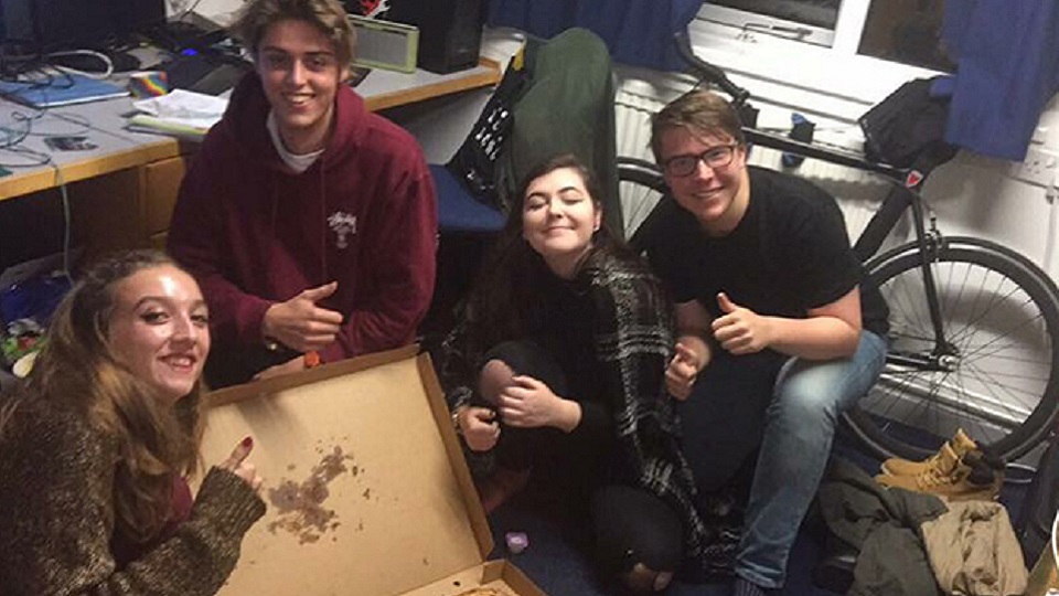 Tara and her flat mates eating pizza. 